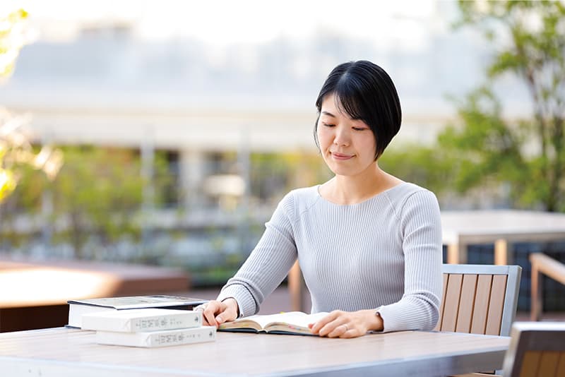 Yuko Ishihara reading outdoors at a table